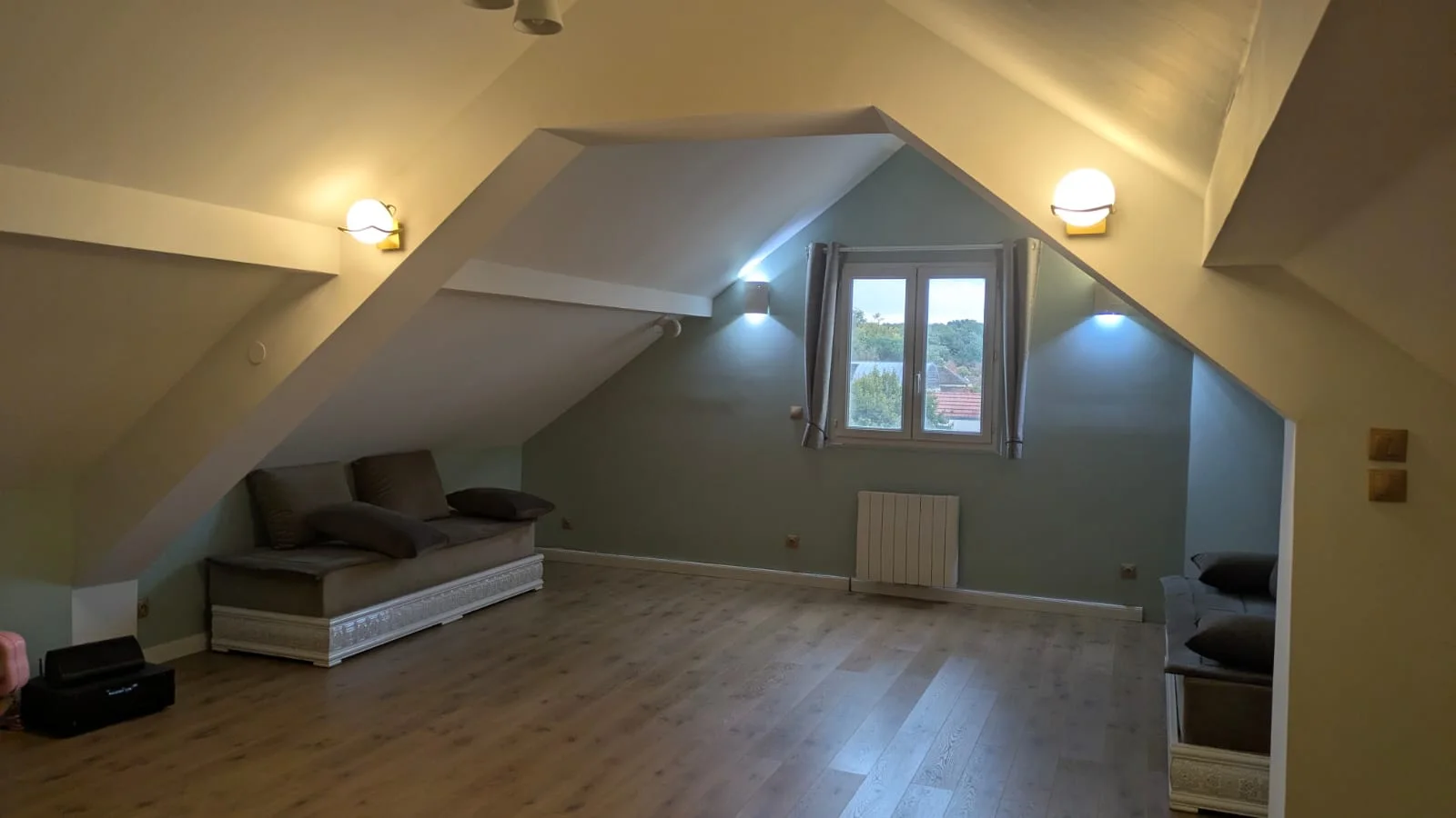 Combles rénovés avec sol stratifié Parador chêne classique et appliques murales