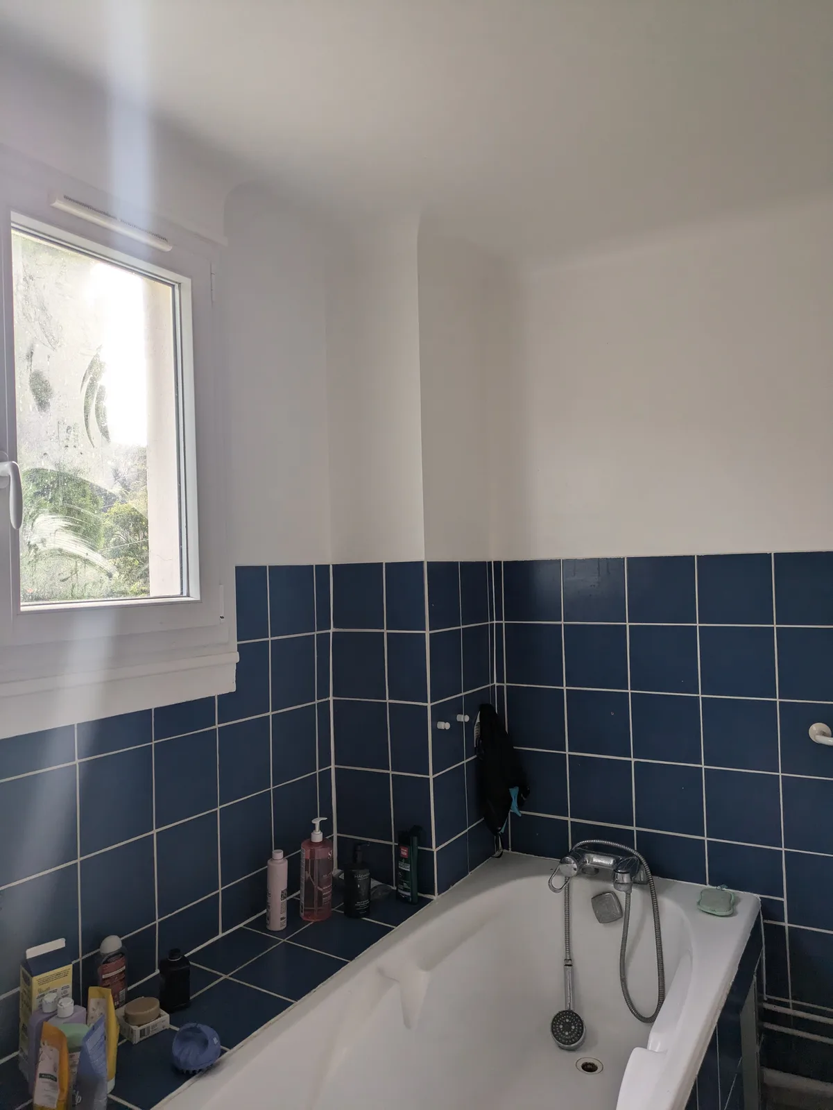 Avant rénovation : baignoire encastrée et faïence bleue